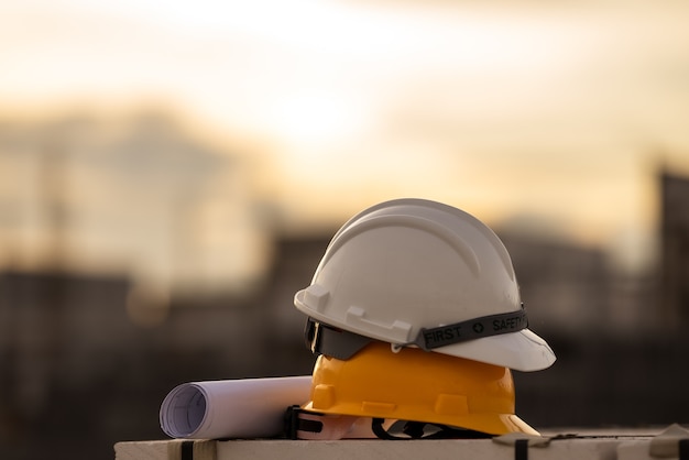 Segurança do capacete branco e amarelo na construção do local, conceito de segurança em primeiro lugar.