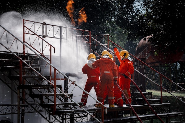 Foto segurança dos bombeiros usando extintor de incêndio do tipo névoa de água para combater o fogo de óleo e