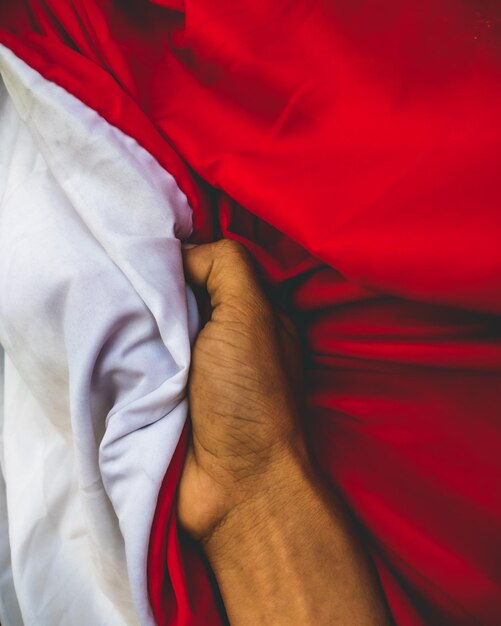 Foto segurando a bandeira indonésia vermelha e branca