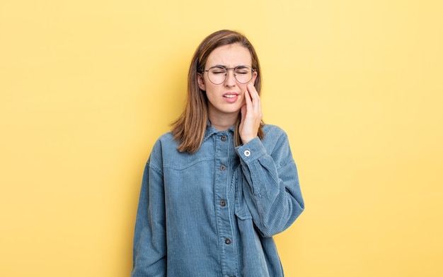 Segurando a bochecha e sofrendo dor de dente dolorosa, sentindo-se doente, miserável e infeliz, procurando um dentista