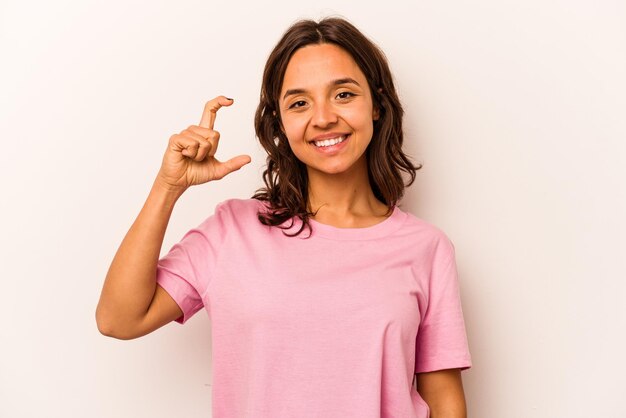 Segurando algo pequeno com o dedo indicador sorrindo e confiante