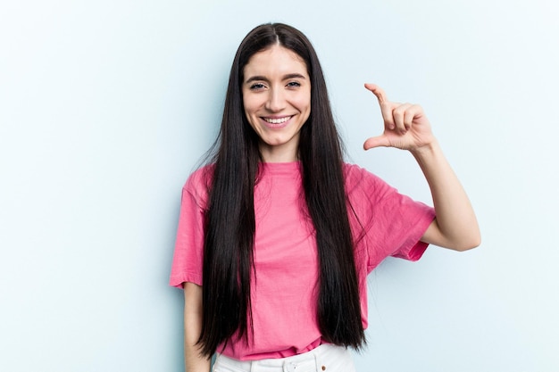 Foto segurando algo pequeno com o dedo indicador sorrindo e confiante