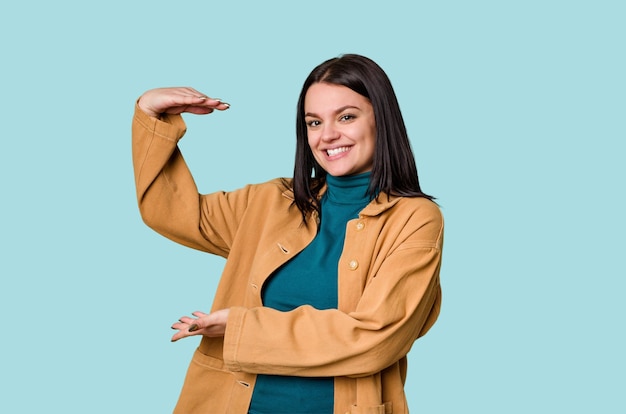 Segurando algo pequeno com o dedo indicador sorrindo e confiante