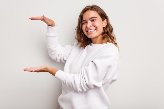 Segurando algo pequeno com os dedos indicadores sorrindo e confiante
