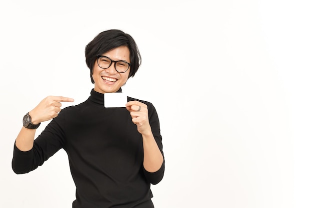 Segurando e mostrando o crédito em branco ou o cartão do banco de um belo homem asiático isolado no fundo branco