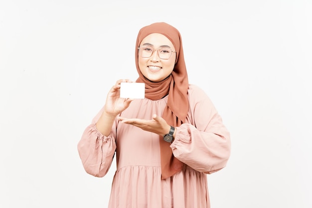 Segurando o cartão de banco em branco ou cartão de crédito de linda mulher asiática usando hijab isolado no branco