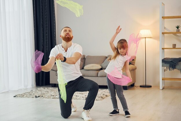 Segurando o pano pai com sua filha está em casa juntos