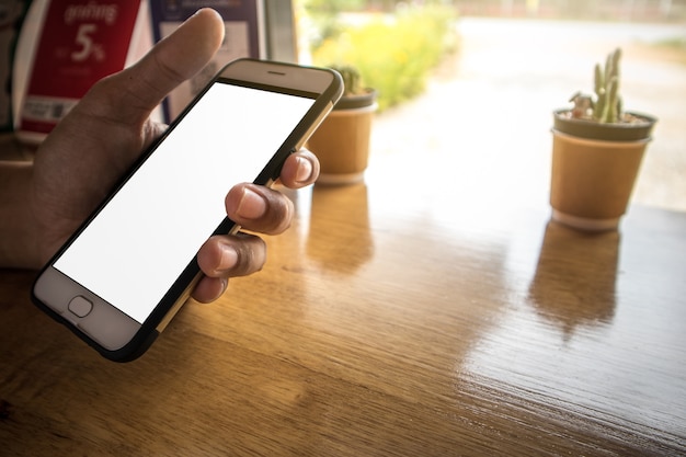 Segurando o telefone celular e jogar aplicativo no café