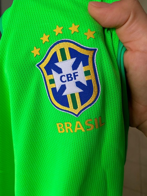 Segurando o uniforme de futebol do brasil, os fãs da copa do mundo verde, amarelo e azul na camiseta