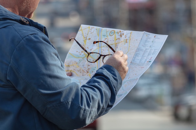 Foto segurando papel de mapa procurando localização