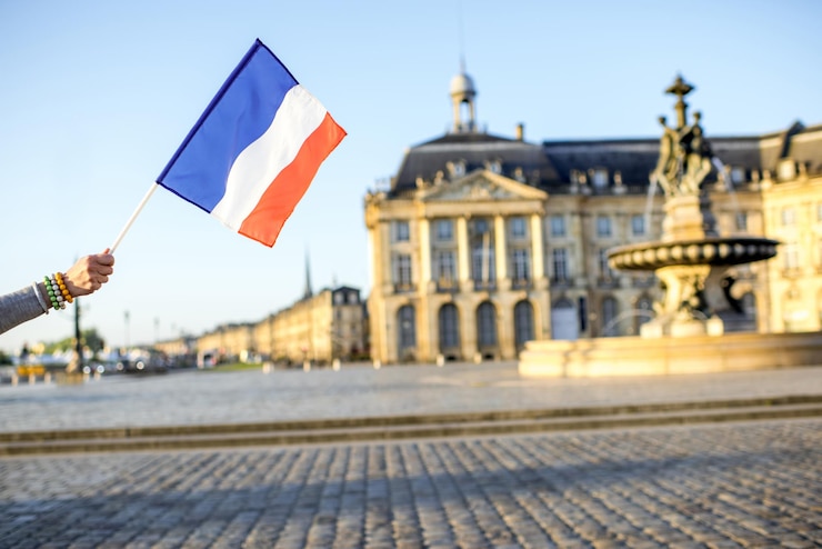 Foto segurando uma bandeira da frança na famosa praça central da cidade de bordeaux