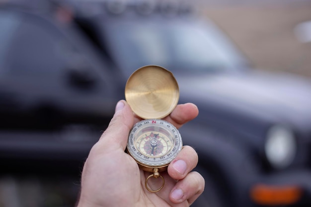 Segurando uma bússola na frente de um carro