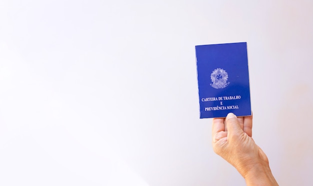 Foto segurando uma carteira de trabalho no brasil, isolada no fundo branco. imagem do conceito.