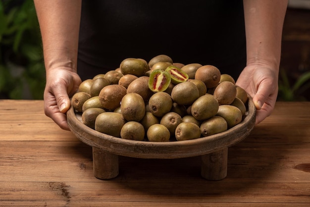 Foto segure o kiwi cortado ou inteiro na mão