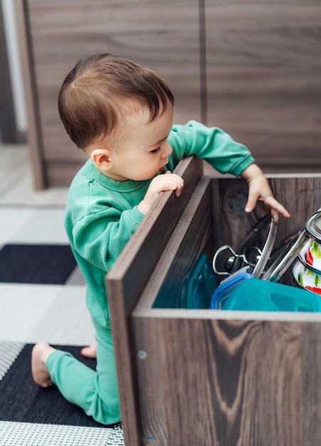 Seguridad del bebé en la cocina Niño pequeño jugando con cajón