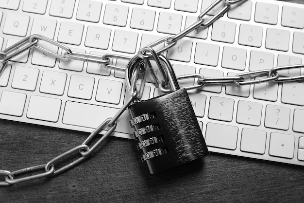 Seguridad cibernética Cerraduro de combinación de metal con cadena y teclado en la vista de la mesa gris