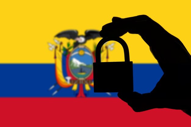 Seguridad de Ecuador Silueta de mano sosteniendo un candado sobre bandera nacional