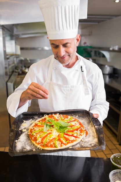 Seguro de chef masculino con comida cocinada en la cocina