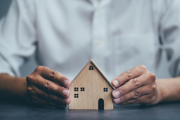 seguro de hogar para la protección de bienes raíces gesto de hombre y modelo de casa