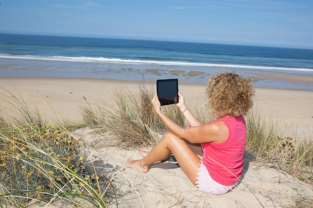 Seguro joven rubia hacer selfie en la playa