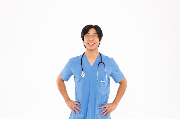 Seguro médico asiático hombre vestido con uniforme y estetoscopio que se encuentran aisladas sobre la pared blanca