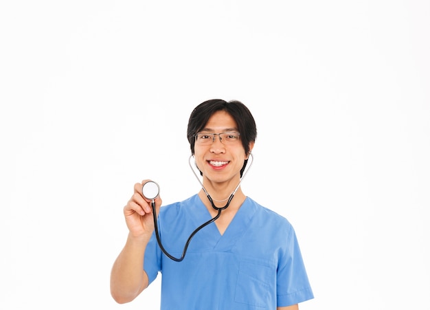 Seguro médico asiático hombre vestido con uniforme y estetoscopio que se encuentran aisladas sobre la pared blanca