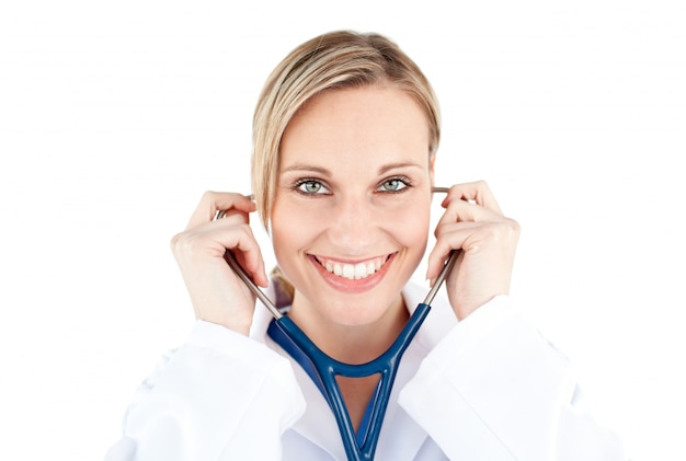 Seguro médico femenina sosteniendo un estetoscopio sonriendo a la cámara
