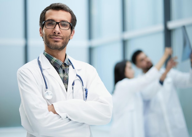 Seguro médico posando con los brazos cruzados está sonriendo a la cámara