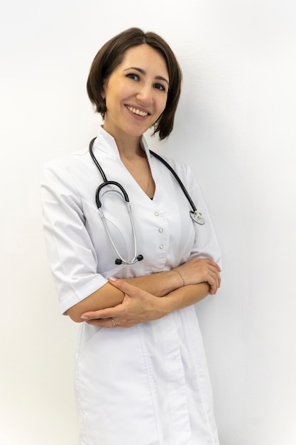 Seguro médico con una túnica blanca se sienta sonriendo a una trabajadora médica con una túnica blanca mira a la cámara