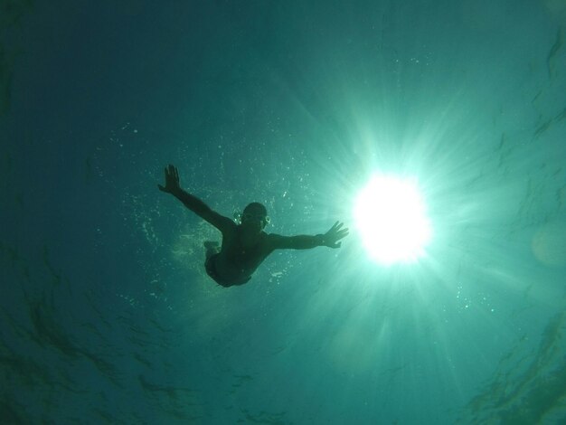 Foto sehenswürdigkeit von einem mann, der im meer schwimmt