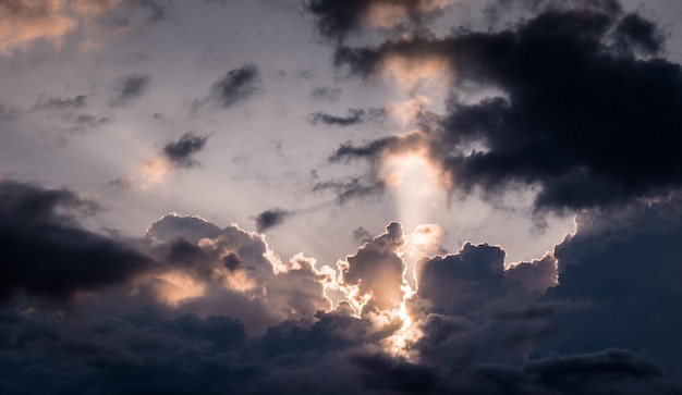 Foto sehenswürdigkeit von sonnenlicht, das während des sonnenuntergangs durch wolken strömt