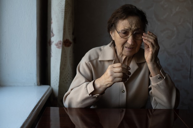 sehr alte frau setzt brille auf