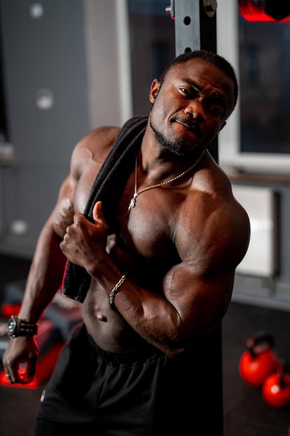 Sehr attraktiver, gutaussehender Afroamerikaner posiert auf dem Hintergrund der Sportausrüstung Sportmodell männlich