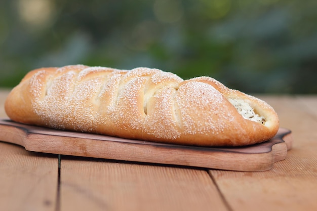 Sehr leckeres und leckeres Gebäck mit Hüttenkäse und Oliven auf einem Holztisch Leckere frische, knusprige Backwaren auf verschwommenem Hintergrund