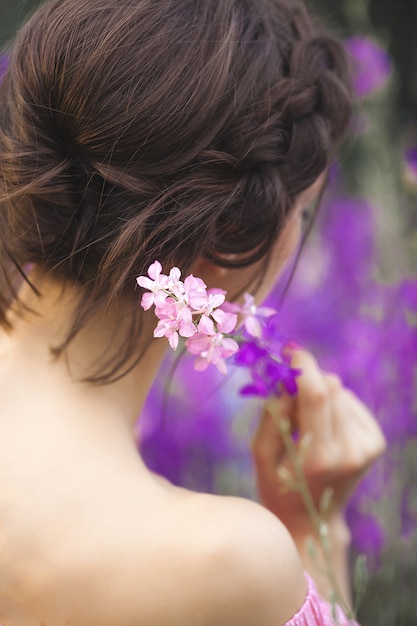 Sehr schöne junge Frau mit Blumen. Nahaufnahmeporträt der attraktiven Frau