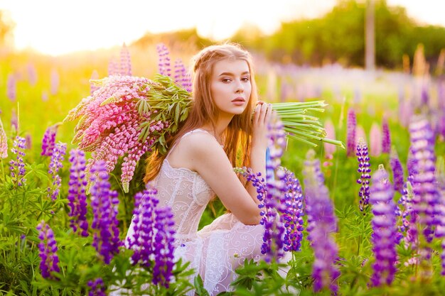 sehr schönes Mädchen mit hellen Blumen auf einem Blumenfeld Helles Blumenfeld mit farbigen Blumen