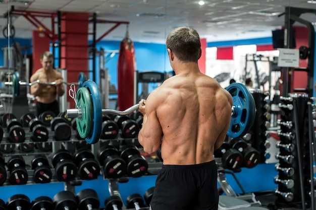 Sehr sportlicher Typ, der im Fitnessstudio steht