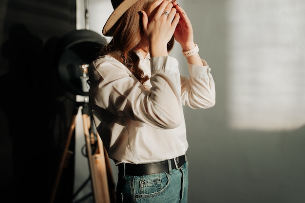 Foto sehr stilvolles mädchen posiert in einem weißen hemd und blauen jeans im fotostudio hautnah