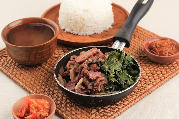 Sei Sapi oder Beef Sei ist traditionelles geräuchertes indonesisches Rindfleisch, das mit gekochten Maniokblättern und Sambal Luat oder Sambal Matah serviert wird. Typisches Essen aus Nusa Tenggara, Indonesien.