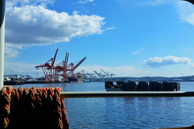 Seil auf Stange am kommerziellen Dock mit Kränen gegen den Himmel