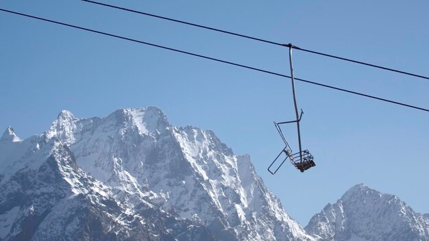 Seilbahn auf dem Hintergrund von Berggipfeln und blauem Himmel kreativer Berglift mit bewegter Leere