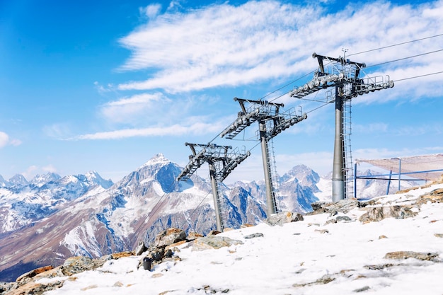 Seilbahn mit Hebemechanismen in den schneebedeckten Bergen an einem klaren, sonnigen Tag vor dem Hintergrund eines blau bewölkten Himmels. Aktive Erholung und Wintersport.