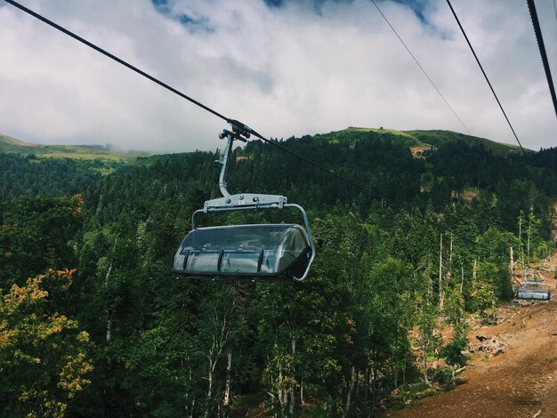 Seilbahn über dem Wald gegen den Himmel