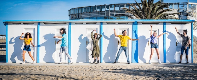 Seis pessoas diversas dançando em frente ao conceito de verão de viagens de cabine de praia