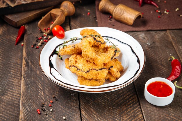 Seitenansicht auf frittierten Garnelen mit Soße auf dem Holztisch