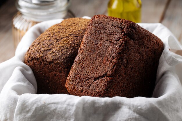 Seitenansicht auf zwei Laib Roggenbrot in einem Korb mit Serviette