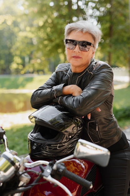 Seitenansicht coole alte Frau mit Motorrad