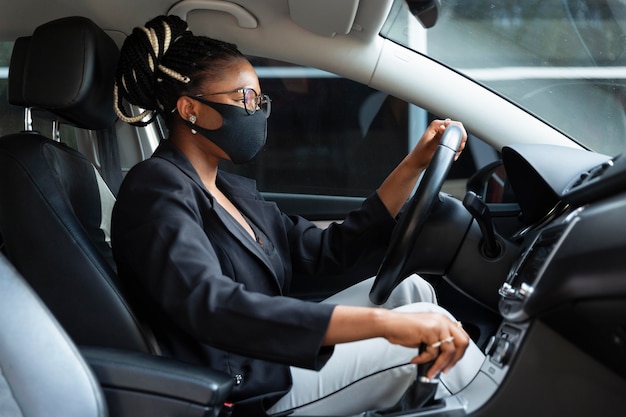 Foto seitenansicht der frau mit fahrendem auto der gesichtsmaske