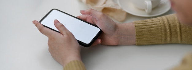 Seitenansicht der Freiberuflerin mit Modell-Smartphone zur Kontaktaufnahme mit dem Kunden