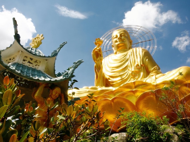 Seitenansicht der goldenen Statue von Buddha an einem sonnigen Tag
